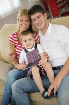 happy young family using tablet computer at modern  home for playing games and education