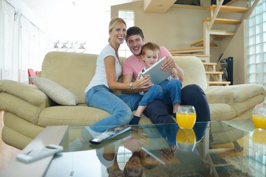 happy young family using tablet computer at modern  home for playing games and education