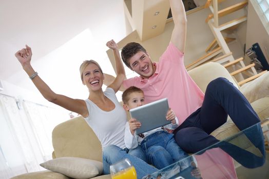 happy young family using tablet computer at modern  home for playing games and education