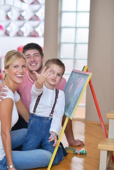 happy young family teach leassons and prepare their son for school while draw on board at home