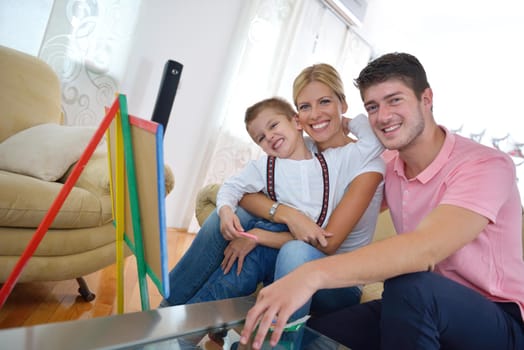 happy young family teach leassons and prepare their son for school while draw on board at home