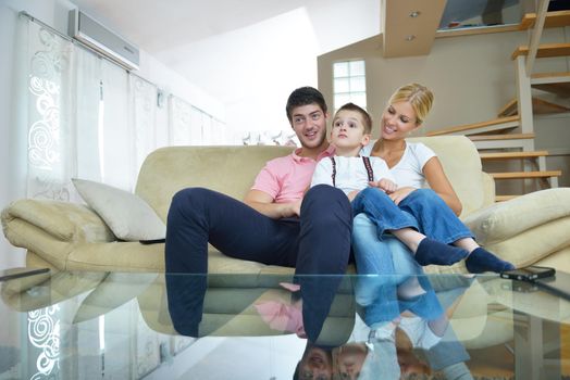 happy young family with kids in bright modern living room have fun and looking big flat lcd tv