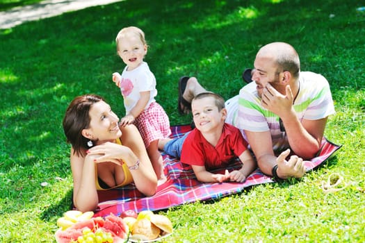 happy young couple with their children have fun at beautiful park outdoor in nature