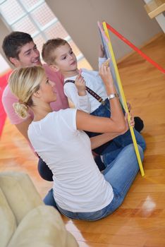 happy young family teach leassons and prepare their son for school while draw on board at home