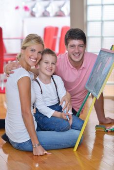 happy young family teach leassons and prepare their son for school while draw on board at home