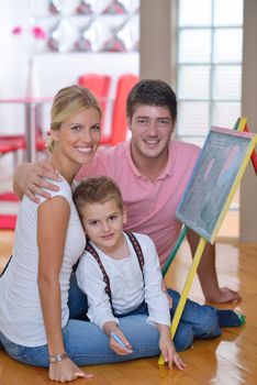 happy young family teach leassons and prepare their son for school while draw on board at home