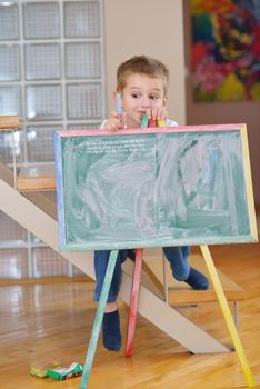 happy young family teach leassons and prepare their son for school while draw on board at home