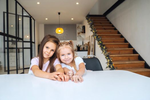 Two little girls at the table looking at the camera