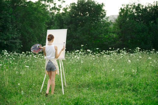 woman artist in aprons paint palette easel nature. High quality photo