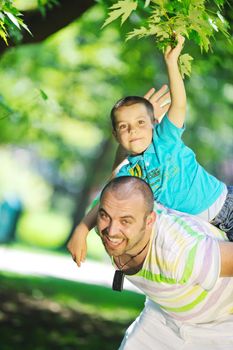 family father and son have fun at park on summer season and representing happines concept