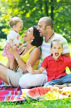 happy young couple with their children have fun at beautiful park outdoor in nature