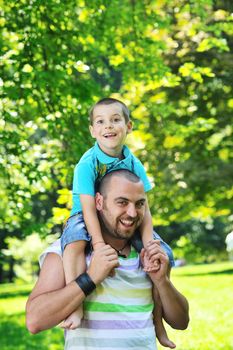 family father and son have fun at park on summer season and representing happines concept