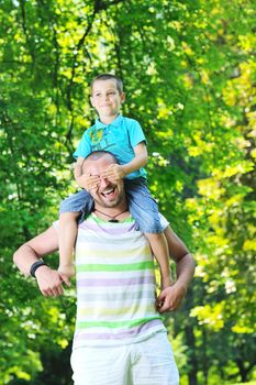 family father and son have fun at park on summer season and representing happines concept