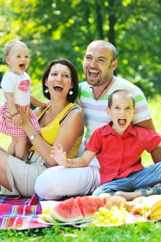 happy young couple with their children have fun at beautiful park outdoor in nature