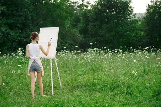 woman artist in aprons paint palette easel nature. High quality photo