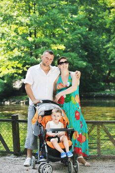 Happy young Family at park relaxing and have fun with pregnant woman