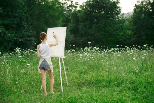 woman artist in aprons paint palette easel nature. High quality photo