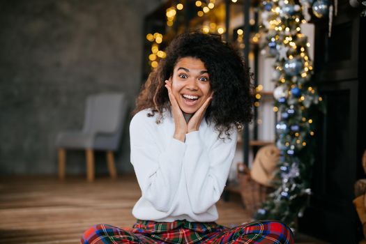 Nice attractive lovely overjoyed woman sits on the floor and looks at the camera