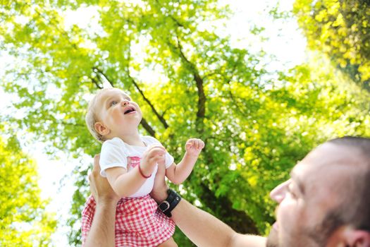 happy family man and baby children playing in bright park while representing happines and parenthood concept