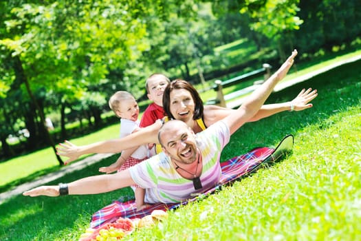 happy young couple with their children have fun at beautiful park outdoor in nature