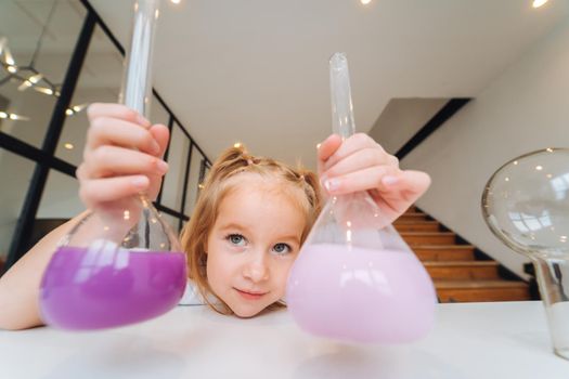 Girl making chemical experiments at home, close view.