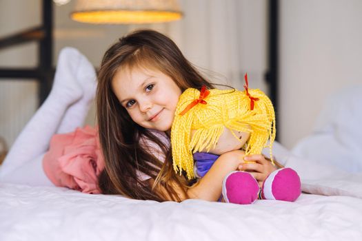 little girl with a toy on the bed, health and beauty concept