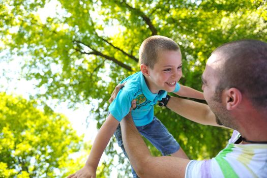 family father and son have fun at park on summer season and representing happines concept