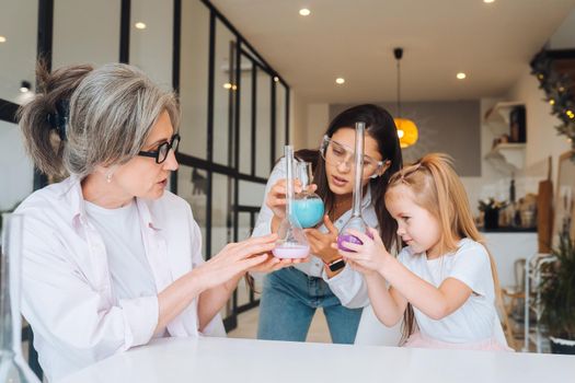 Family doing chemical experiment, mixing flasks indoors, close view.