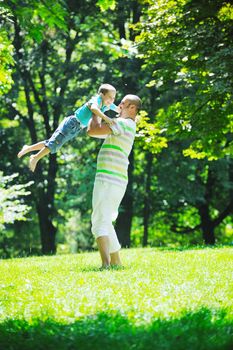 family father and son have fun at park on summer season and representing happines concept