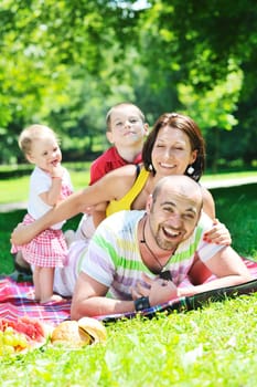 happy young couple with their children have fun at beautiful park outdoor in nature