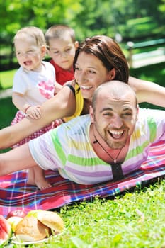 happy young couple with their children have fun at beautiful park outdoor in nature