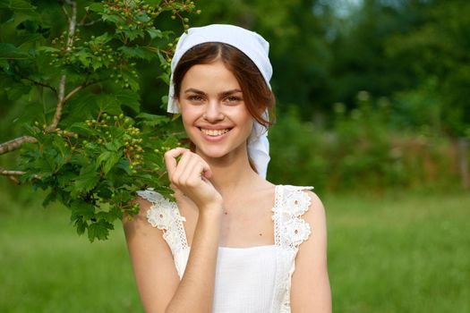 Woman in white dress in the village outdoors Green grass Farmer. High quality photo