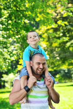 family father and son have fun at park on summer season and representing happines concept