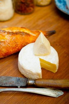 French cheese and fresh  baguette on a wood cutter