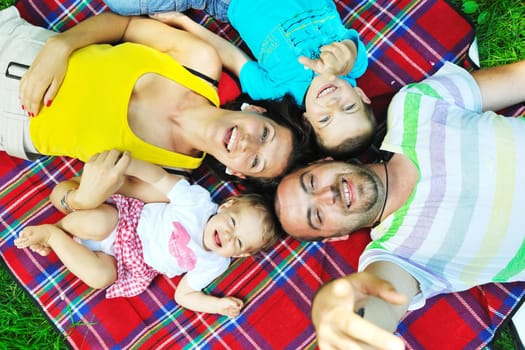 happy young couple with their children have fun at beautiful park outdoor in nature