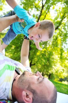 family father and son have fun at park on summer season and representing happines concept