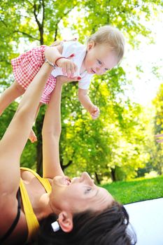 happy young woman and baby have fun while playing in beautiful bright park at summer season