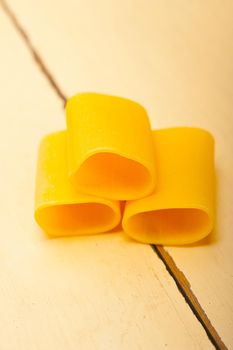 Italian pasta paccheri or schiaffoni macro closeup over white table