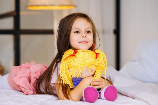 little girl with a toy on the bed, health and beauty concept