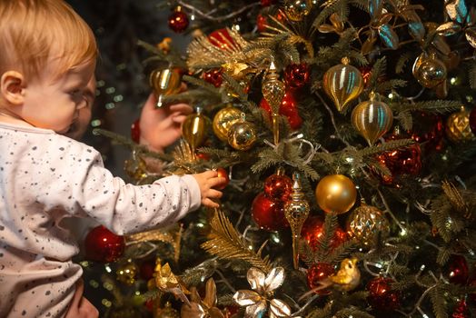 Child celebrating holidays near Christmas tree