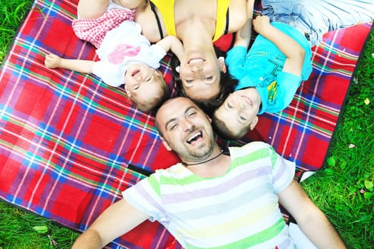 happy young couple with their children have fun at beautiful park outdoor in nature