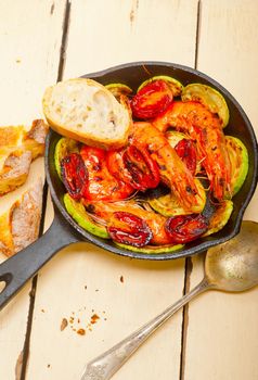 roasted shrimps on cast iron skillet  with zucchini and tomatoes