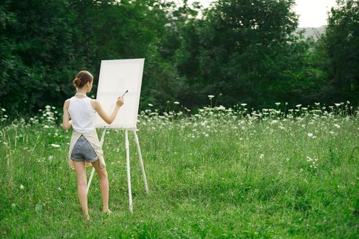 woman artist in aprons paint palette easel nature. High quality photo