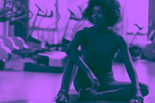 beautiful young african american woman exercise yoga in gym duo tone filter