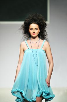 young beautiful model walking on fashion show piste