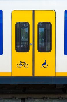 Door of yellow train in railway station in the Netherlands.