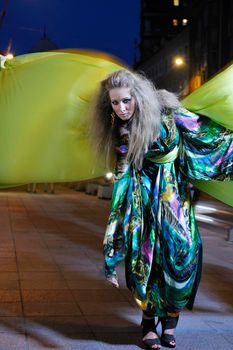 one beautiful young elegant woman in fashion and urban style dress in  city on  street at night alone