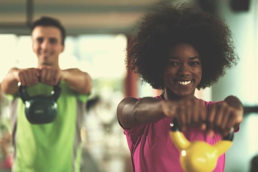 healthy couple  workout with weights lifting  dumbbels at  crossfit gym african  american woman with afro hairstyle