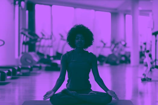 beautiful young african american woman exercise yoga in gym duo tone filter