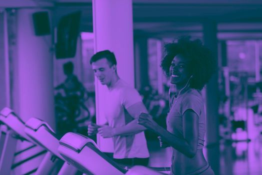 young people exercisinng a cardio on treadmill running machine in modern gym duo tone filter